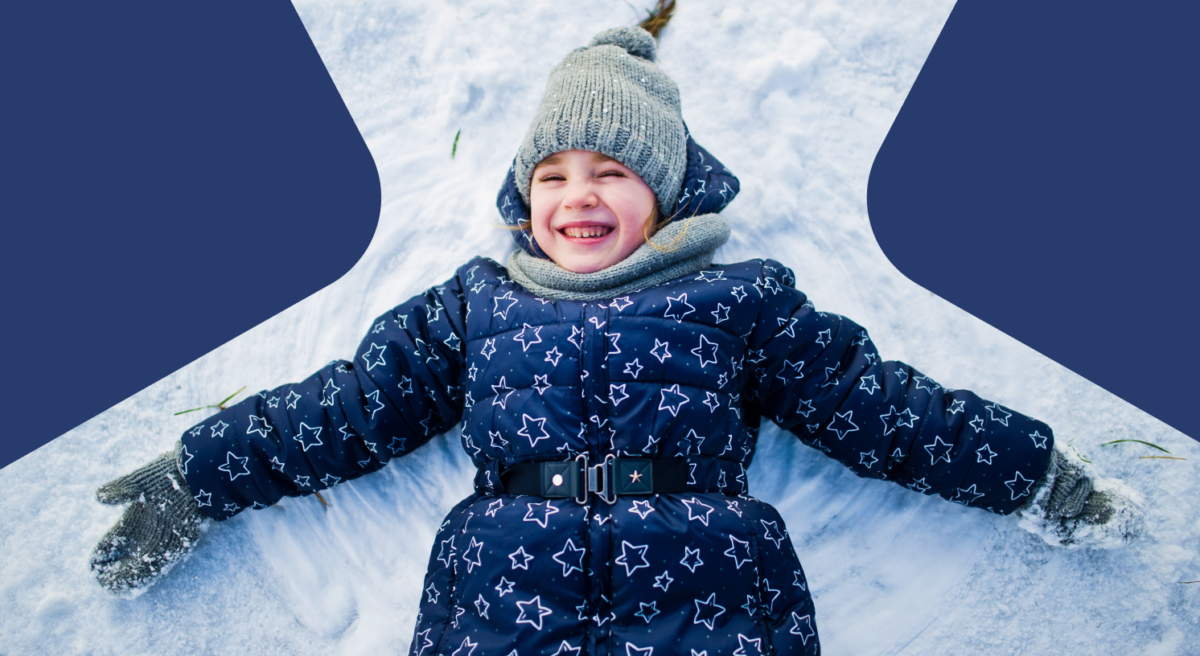 Happy kid laying on a snow.