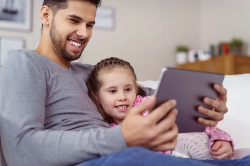 Father and his daughter using a tablet.