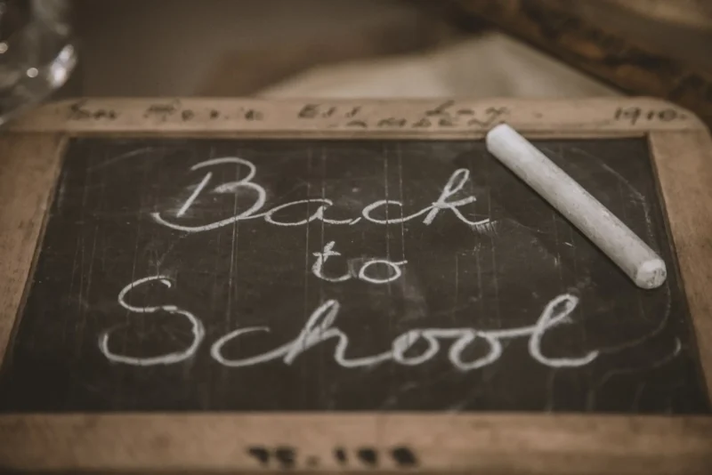 Blackboard and chalk. Text on black board says Back to School.